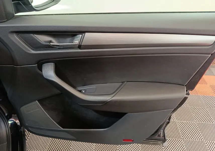 Vue rapprochée de la porte avant gauche noire du Skoda Kodiaq 2021 avec garniture noire et insert bois.