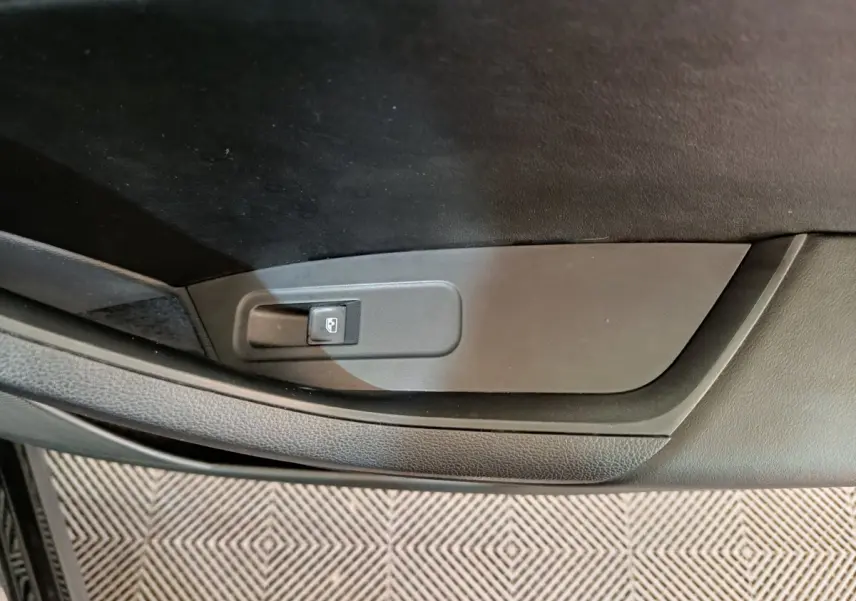 Gros plan sur le bouton de verrouillage centralisé côté gauche de la porte intérieure noire du Skoda Kodiaq 2021.