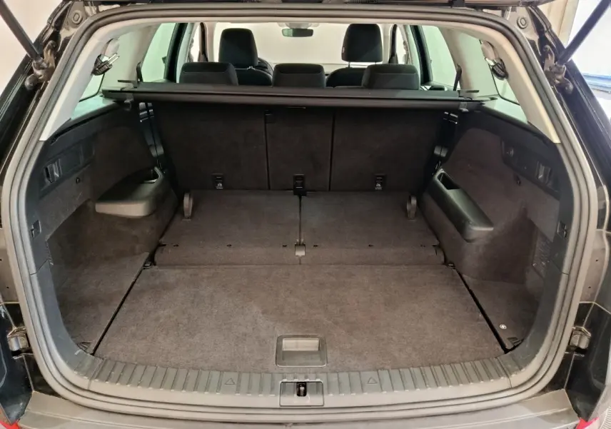 Coffre ouvert vue arrière d'un Skoda Kodiaq noir 2021 avec sièges rabattus et plancher plat.