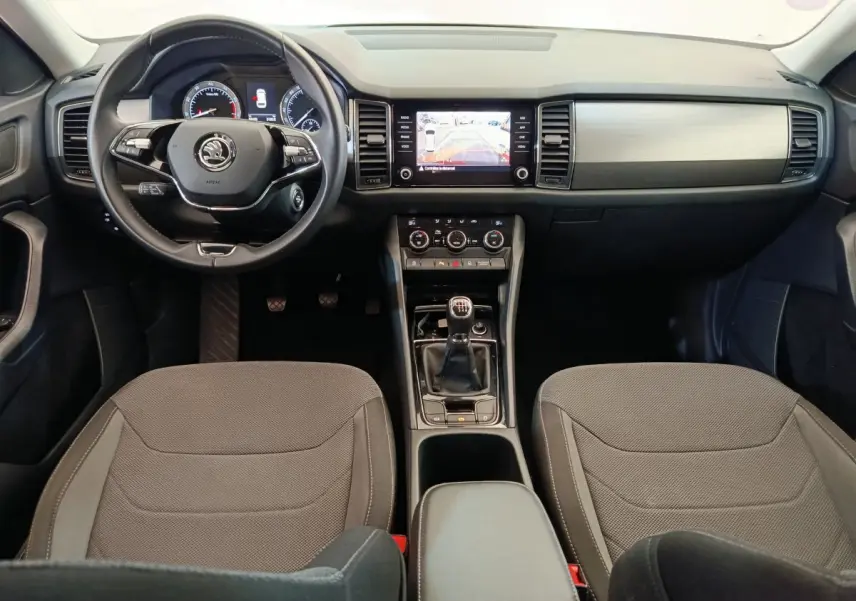 Intérieur du Skoda Kodiaq noir 2021, vue frontale du tableau de bord avec volant cuir et boîte manuelle.