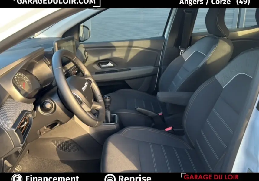 Vue intérieure côté conducteur du Dacia Sandero Expression TCe 90 2025, sièges noirs avec surpiqûres et volant multifonction.