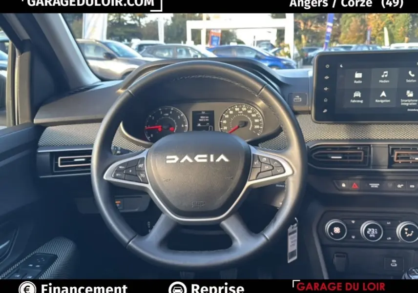 Vue intérieure centrée sur le volant noir DACIA avec tableau de bord et écran tactile du Sandero Expression TCe 90 blanc 2025.