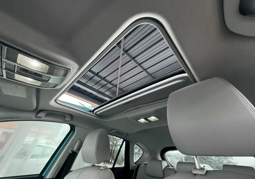 Toit ouvrant panoramique ouvert vu de l'intérieur avant du Mazda CX-5 2013, sièges en cuir gris clair.
