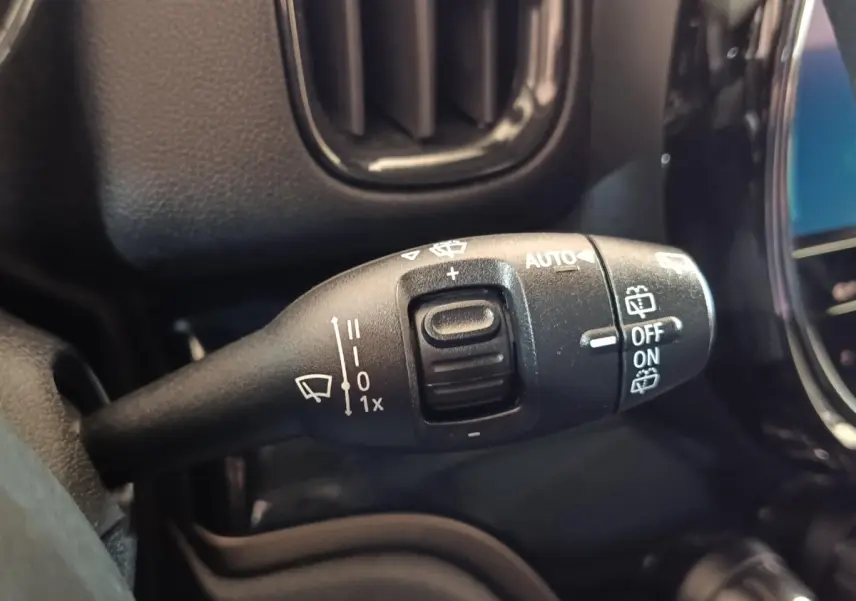 Gros plan sur la commande des essuie-glaces du MINI Countryman Cooper SE noir, avec marquages blancs et bouton central.