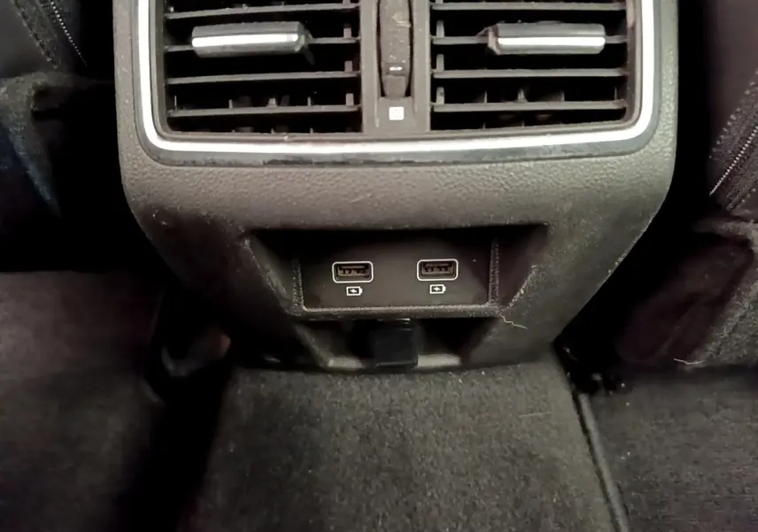 Prise USB double et sortie d’aération arrière dans l’habitacle noir de la Renault Megane Business E-Tech hybride rechargeable.