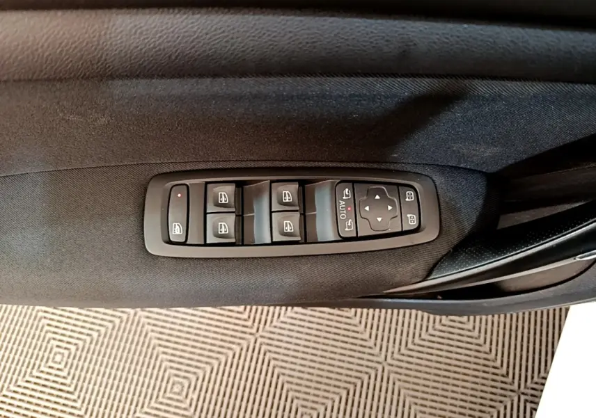 Commande des vitres et rétroviseurs sur la porte côté conducteur d’une Renault Mégane Business E-Tech blanche, vue intérieure.