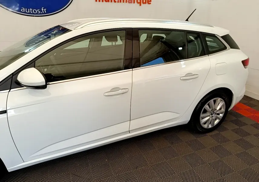 Profil droit de la Renault Mégane Business E-Tech hybride rechargeable blanche, avec jantes alliage et rétroviseurs blancs.