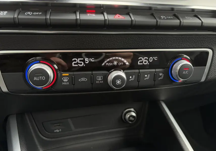 Gros plan sur la commande de climatisation automatique bi-zone de l'Audi Q2 30 TFSI S-Line blanche de 2024.