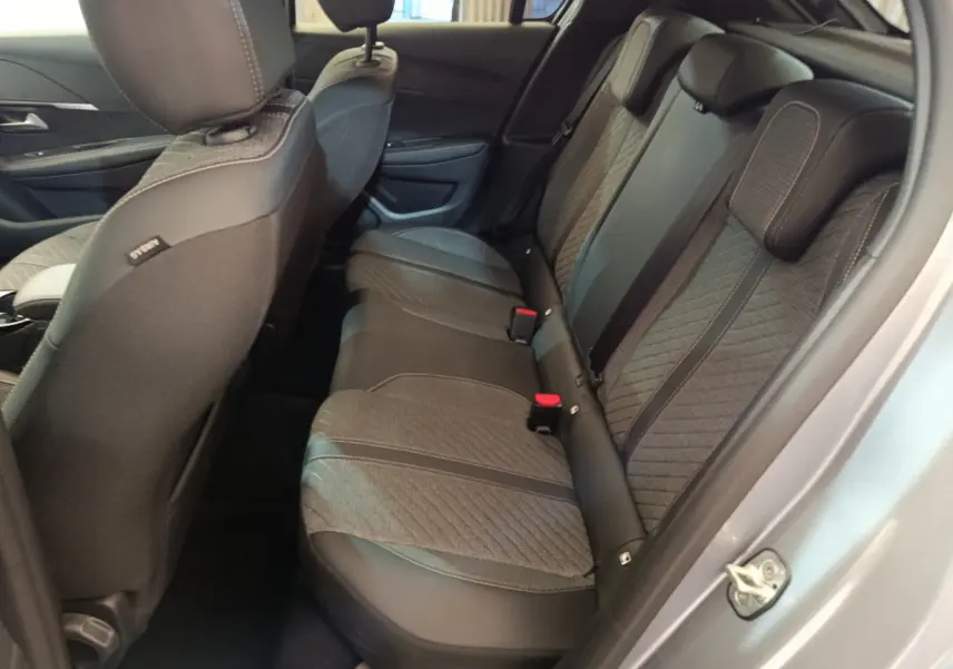 Vue côté droit de la banquette arrière grise claire de la Peugeot 208 PureTech 100 S&S Allure avec sellerie mixte tissu et cuir.
