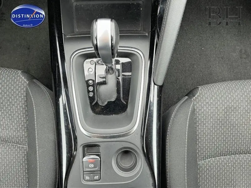 Vue plongeante sur la console centrale du Renault Kadjar 2018, avec levier de boîte auto et sièges tissu carbone foncé.