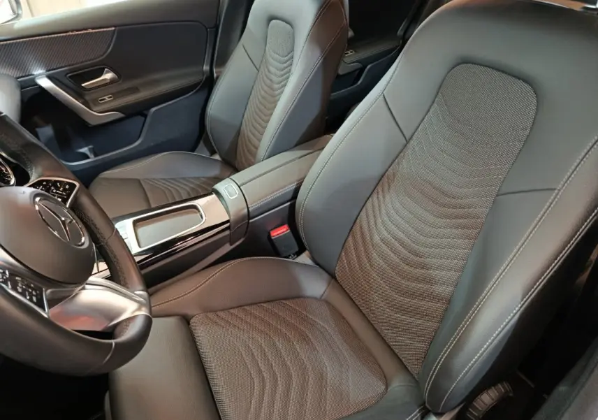 Vue intérieure rapprochée des sièges avant gris foncé et volant cuir alu de la Mercedes Classe A 250 e Business Line 2023.