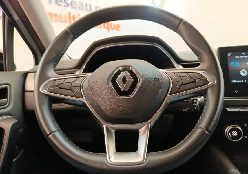 Vue rapprochée du volant en cuir noir du Renault Captur Intens E-TECH 2021 avec commandes intégrées et logo central.