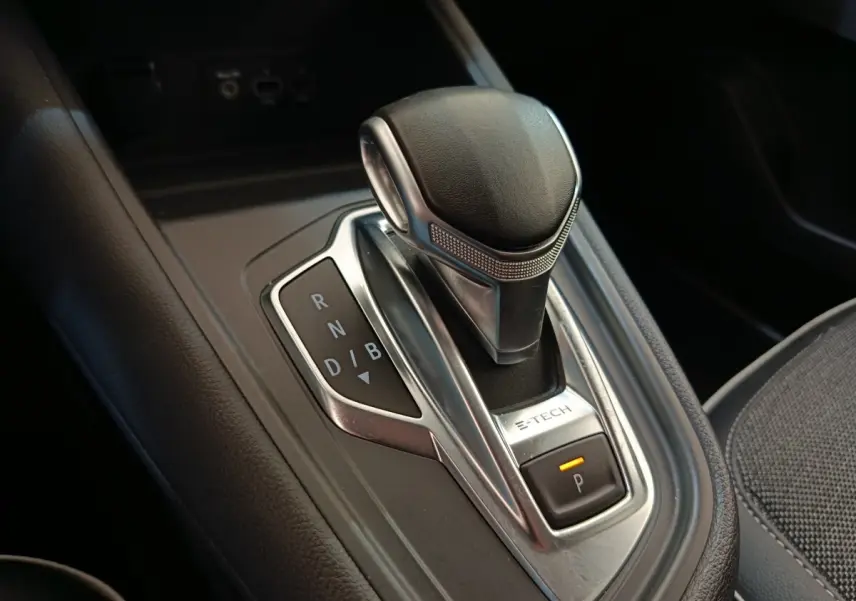 Gros plan sur le levier de vitesses automatique E-TECH du Renault Captur gris clair, avec indication des modes de conduite.