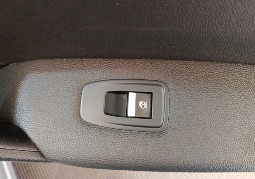 Gros plan sur l'interrupteur de lève-vitre automatique côté conducteur du Renault Captur gris clair Intens E-TECH 2021.