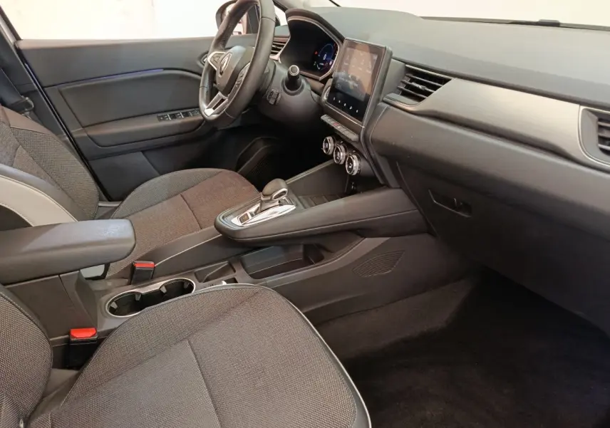 Vue intérieure côté conducteur du Renault Captur Intens E-TECH 2021, montrant tableau de bord noir et écran tactile central.