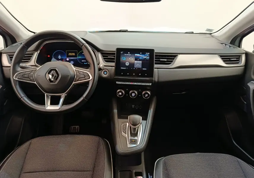 Vue intérieure avant du Renault Captur Intens E-TECH 2021, tableau de bord noir avec écran tactile central et volant multifonctions.