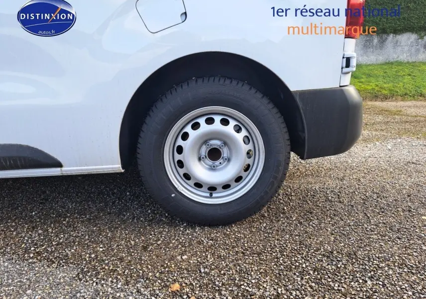 Gros plan sur la roue arrière droite d'un Peugeot Expert Blanc Kaolin, avec passage de roue et partie de la carrosserie visible.