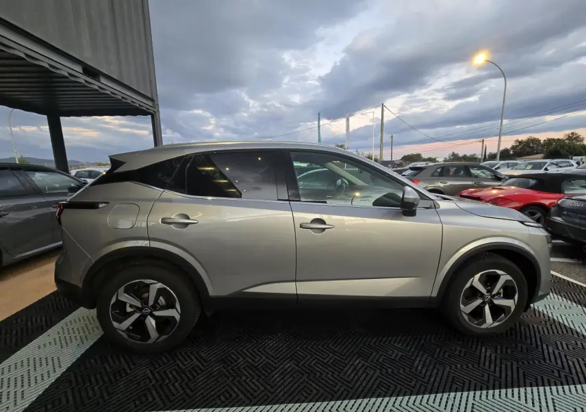 Nissan Qashqai III gris silver vu de profil côté gauche, avec jantes alliage 18 pouces et vitres teintées arrière.