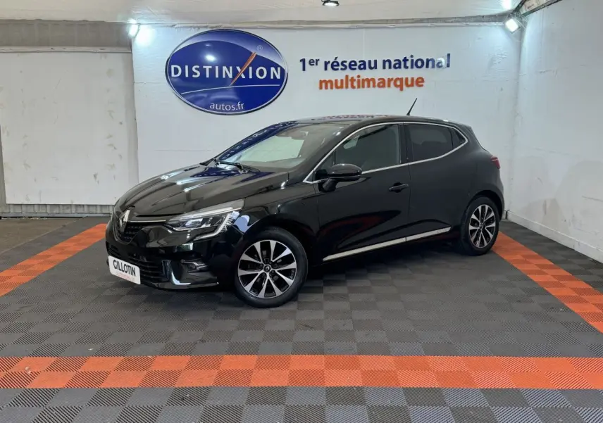 Renault Clio Intens TCe 100 noire vue de profil côté gauche dans un showroom avec sol gris et bandes orange.