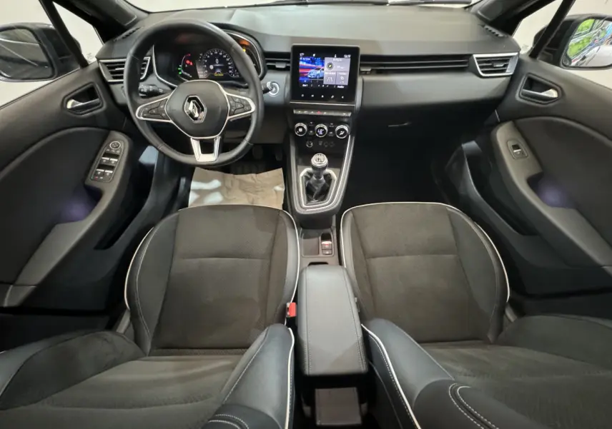 Vue intérieure avant de la Renault Clio Intens TCe 100 noire, avec tableau de bord moderne et écran tactile central.