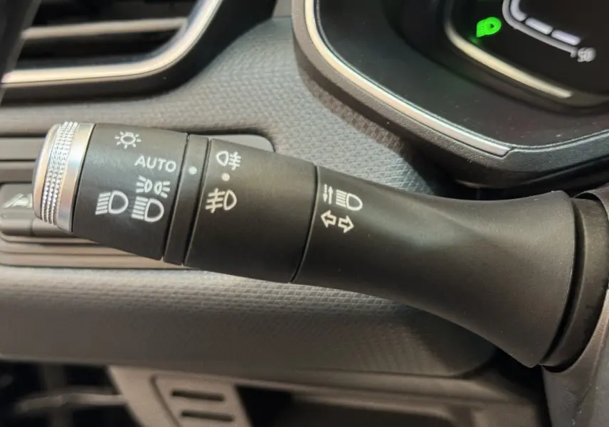 Gros plan sur la commande des phares et clignotants dans l'habitacle noir de la Renault Clio Intens TCe 100 2020.