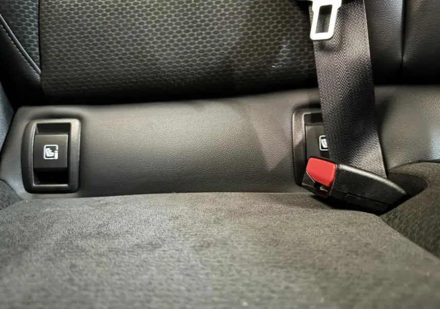 Gros plan sur la banquette arrière noire de la Renault Clio Intens avec ceintures et fixations Isofix visibles.