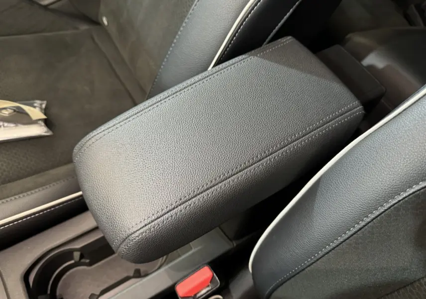 Accoudoir central en cuir noir avec surpiqûres blanches dans l'habitacle de la Renault Clio Intens TCe 100 2020.