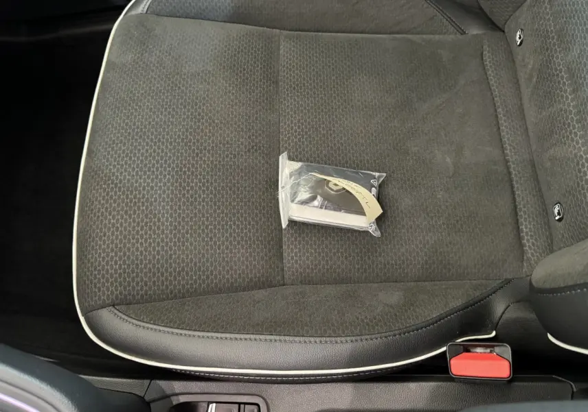 Gros plan sur le siège avant droit noir de la Renault Clio Intens 2020 avec clé dans un sachet plastique posé dessus.