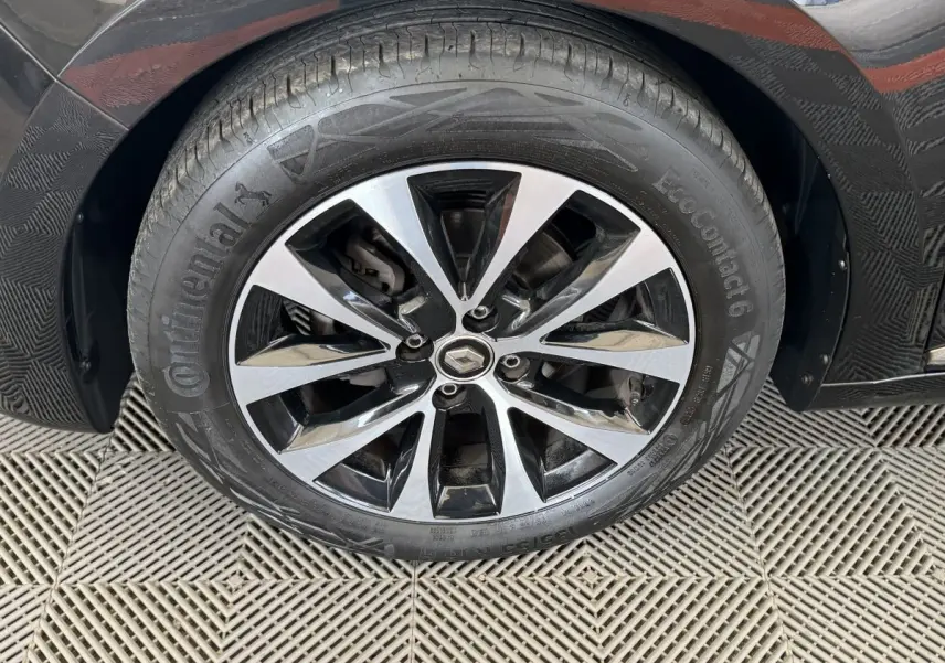 Gros plan sur la roue avant droite noire d'une Renault Clio Intens TCe 100 avec jante alliage bicolore.