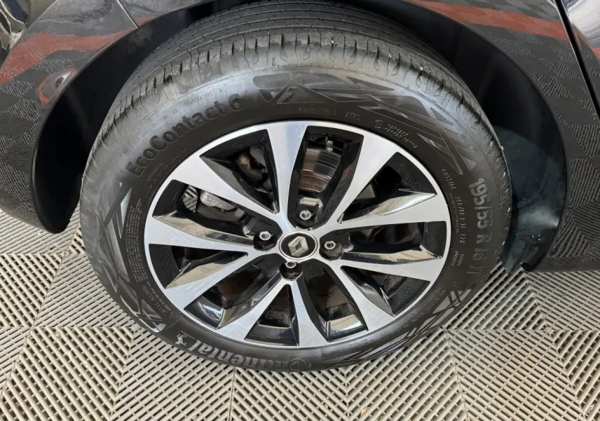 Gros plan sur la roue avant gauche noire d'une Renault Clio Intens TCe 100 avec jante alliage bicolore.