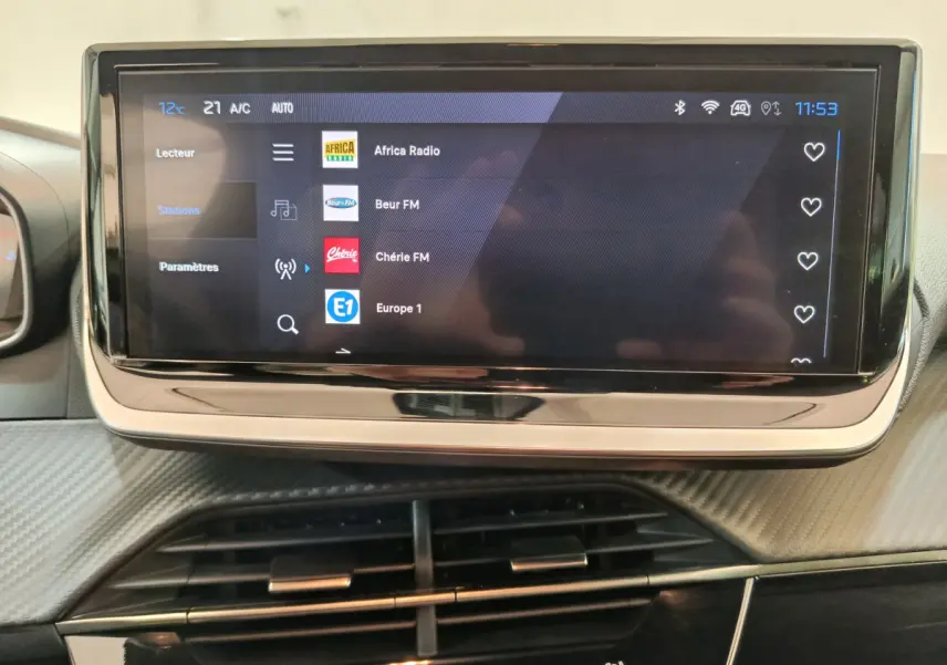 Écran tactile central de la Peugeot 208 PureTech 100 Allure affichant les stations radio, vue intérieure rapprochée.