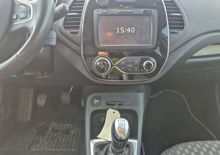 Vue intérieure centrée sur la console centrale d'une Renault Captur beige/marron 2018 avec levier de vitesse manuel et écran tactile.