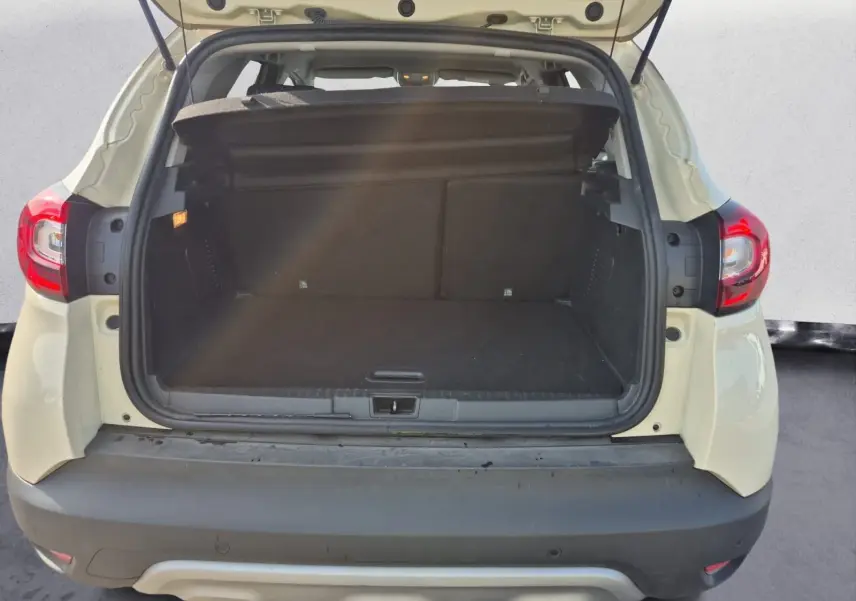 Vue arrière du coffre ouvert d'un Renault Captur beige/marron 2018, montrant l'espace de chargement vide.
