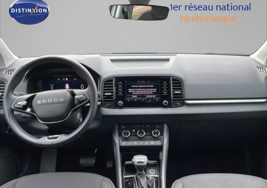 Vue intérieure frontale du Skoda Karoq blanc glacier 2025, avec tableau de bord moderne et écran tactile central.