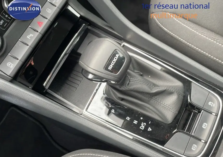 Gros plan sur le levier de vitesse automatique noir marqué SKODA dans l’habitacle du Karoq 2025.
