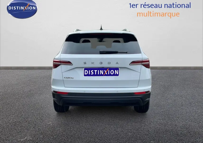 Vue arrière d'un Skoda Karoq blanc glacier 2025 avec feux LED et logo distinctif sur fond neutre.
