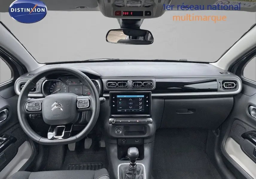 Intérieur avant de la Citroën C3 2021 gris avec tableau de bord moderne et boîte manuelle visible au centre.