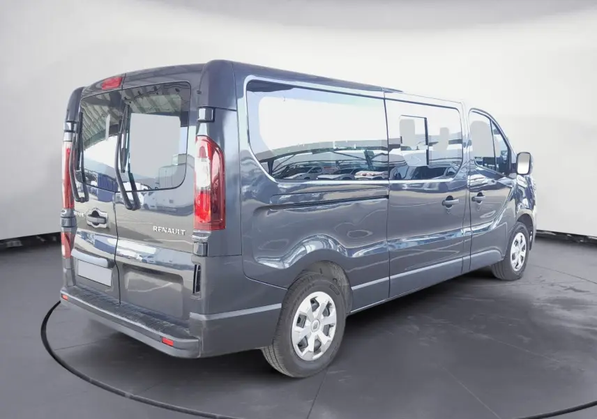 Renault Trafic Combi gris foncé métal vu en 3/4 arrière droit, avec vitres latérales et portes arrière vitrées.