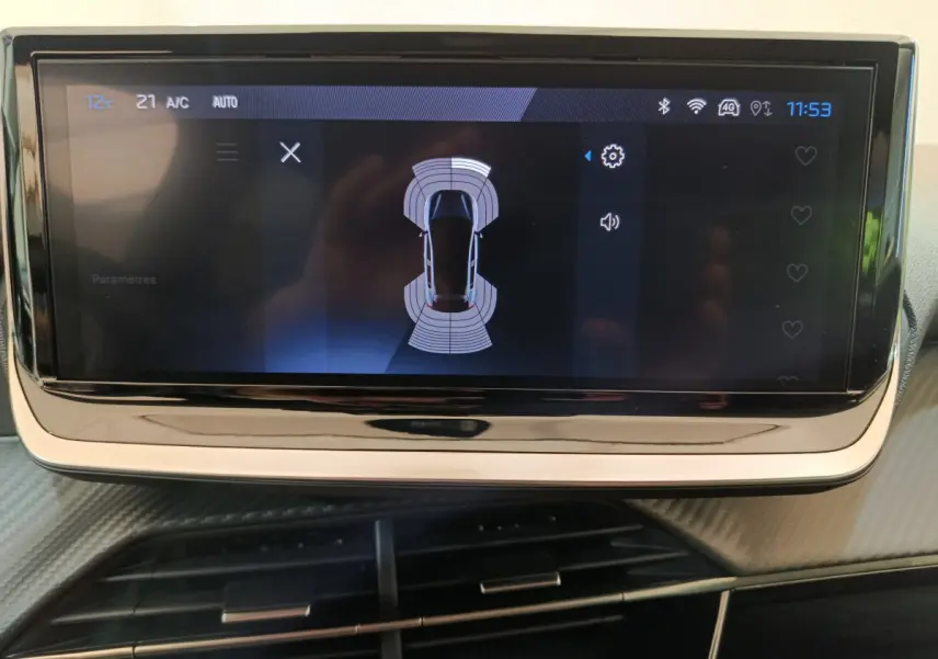 Écran tactile central affichant l'aide au stationnement de la Peugeot 208 gris clair, vue intérieure rapprochée