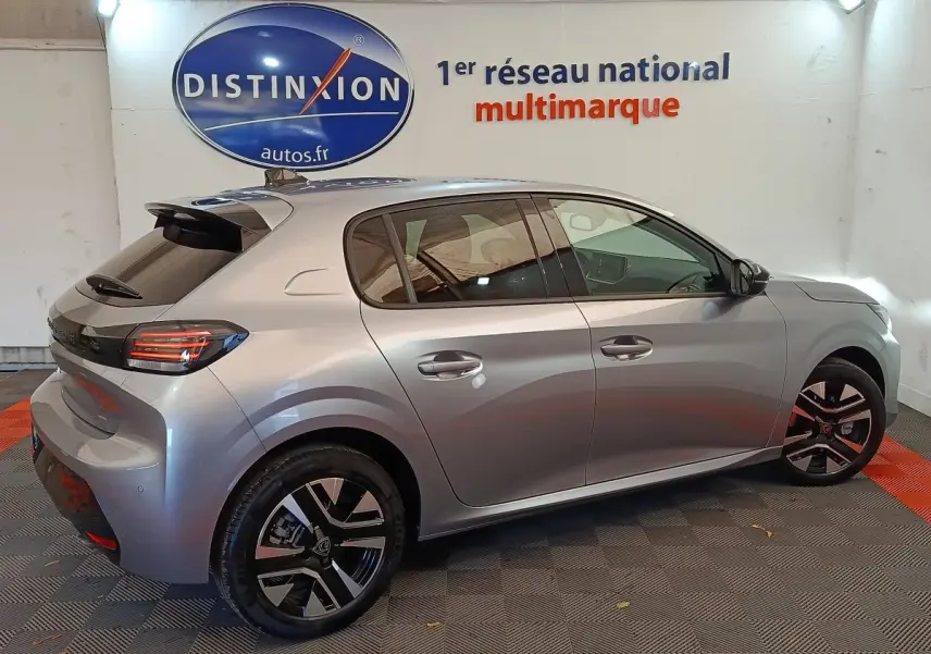 Vue côté droit arrière d'une Peugeot 208 gris clair 2025 avec jantes noires et feux arrière LED distinctifs.