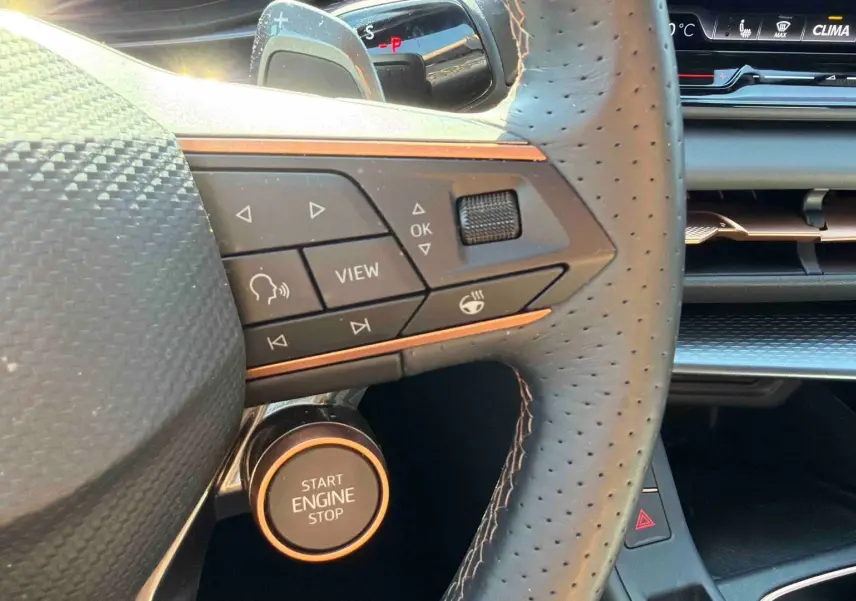 Gros plan sur le volant cuir perforé et la commande Start Engine Stop du tableau de bord du CUPRA Terramar 2025.