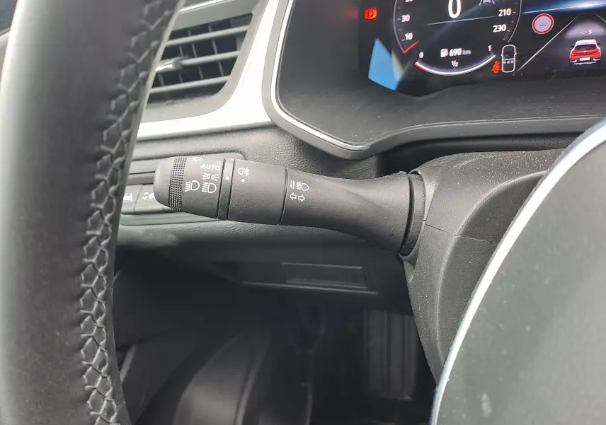 Gros plan sur la manette de clignotant à gauche du volant dans l'habitacle noir du Renault Captur TCE 90CH TECHNO 2024.