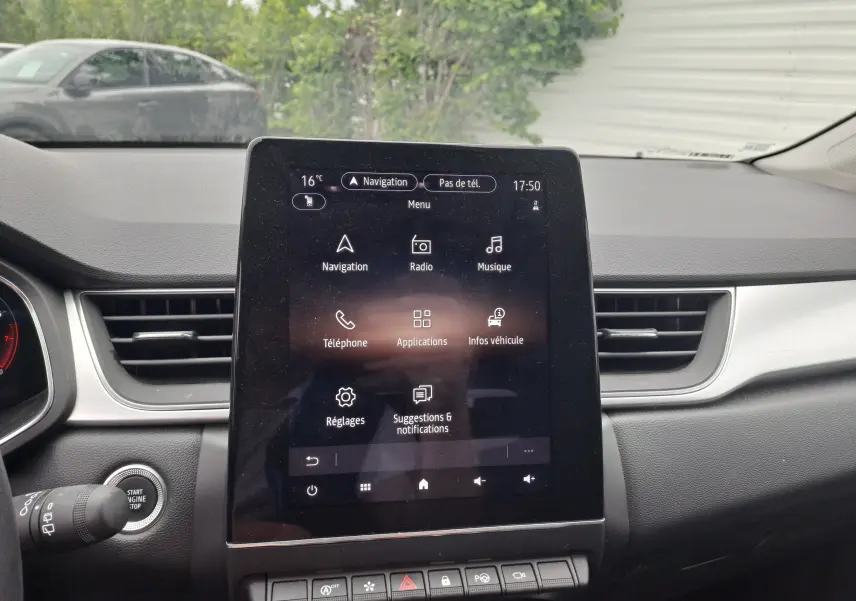 Écran tactile central du tableau de bord du Renault Captur 2024, affichant le menu principal avec navigation et radio.