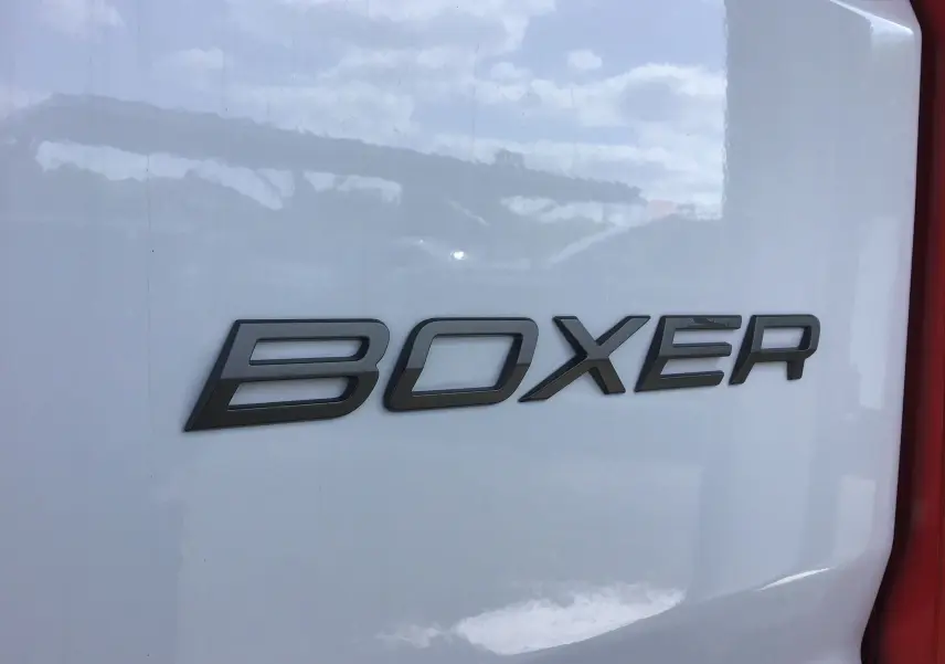Gros plan sur l’inscription BOXER en noir sur la porte arrière blanche d’un utilitaire Peugeot Boxer 2025.