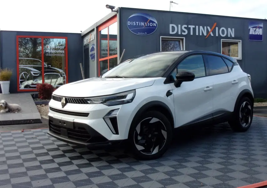 Renault Captur E-Tech blanc nacré vu de 3/4 avant droit sur parking extérieur avec plusieurs véhicules alignés.