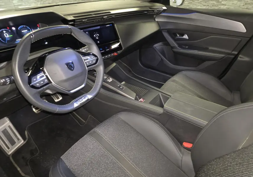 Vue intérieure côté conducteur de la Peugeot 408 gris, avec volant compact, écran tactile et sellerie tissu/TEP noire.