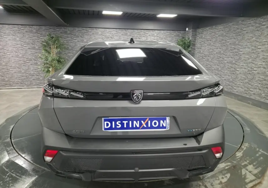 Vue arrière d'une Peugeot 408 gris métallisé avec logo lion noir et feux arrière à LED griffés.