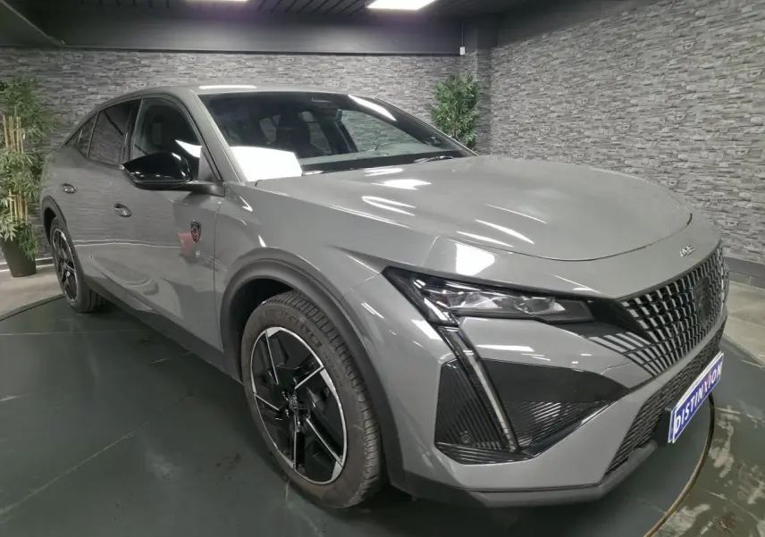 PEUGEOT 408 gris Selenium en 3/4 avant droit, avec calandre verticale et jantes alliage 19 pouces diamantées Graphite.