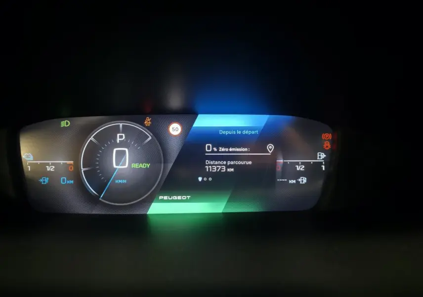 Tableau de bord numérique Peugeot 408 2025 affichant vitesse, autonomie et distance parcourue, éclairage multicolore.