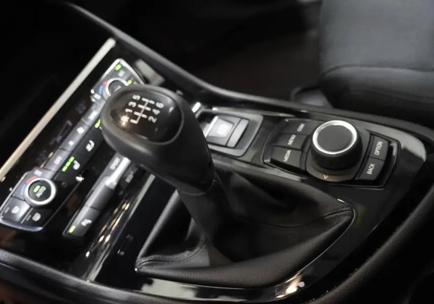 Gros plan sur la commande de boîte manuelle et la console centrale noire du BMW Série 2 Active Tourer 216d.